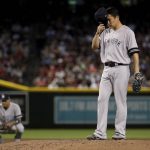 New York Yankees' Gio Urshela kneels as starting pitcher Masahiro Tanaka adjusts his cap after giving up a run on a wild pitch against the Arizona Diamondbacks during the second inning of a baseball game, Wednesday, May 1, 2019, in Phoenix. (AP Photo/Matt York)