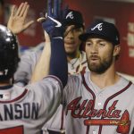 Atlanta Braves' Dansby Swanson, left, is congratulated, after scoring against the Arizona Diamondbacks, by Charlie Culberson, right, during the fourth inning of a baseball game Friday, May 10, 2019, in Phoenix. (AP Photo/Ross D. Franklin)