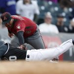 Arizona Diamondbacks third baseman Eduardo Escobar, back, tags out Colorado Rockies' Ian Desmond as he slides into third base while trying to stretch a double into a triple in the second inning of a baseball game Wednesday, May 29, 2019, in Denver. (AP Photo/David Zalubowski)