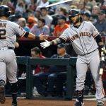 San Francisco Giants' Joe Panik (12) is congratulated by Brandon Crawford after scoring against the Arizona Diamondbacks during the first inning of a baseball game Saturday, May 18, 2019, in Phoenix. (AP Photo/Ralph Freso)