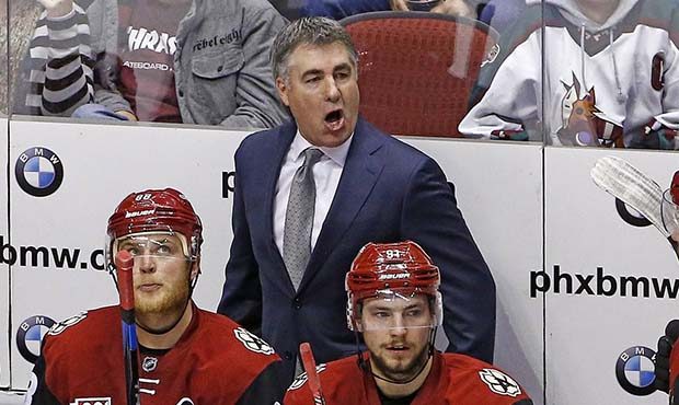 Arizona Coyotes coach Dave Tippett, top, argues with officials as he shouts over left wing Jamie Mc...