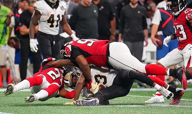 Michael Thomas #13 of the New Orleans Saints is tackled by Damontae Kazee #27 and Terrell McClain #...