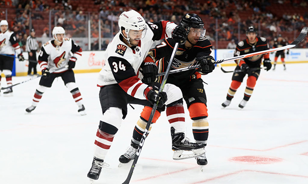 Andrew Cogliano #7 of the Anaheim Ducks pushes Robbie Russo #34 of the Arizona Coyotes during the t...