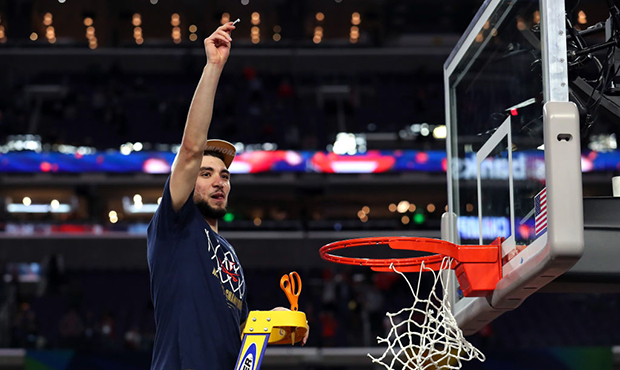 Ty Jerome #11 of the Virginia Cavaliers cuts down the net after his teams 85-77 win over the Texas ...