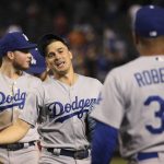 Los Angeles Dodgers' Enrique Hernandez, middle, celebrates with manager Dave Roberts (30) as Alex Verdugo, left, looks in another direction after the team's baseball game against the Arizona Diamondbacks on Tuesday, June 25, 2019, in Phoenix. The Dodgers won 3-2. (AP Photo/Ross D. Franklin)