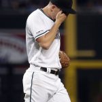 Arizona Diamondbacks starting pitcher Taylor Clarke wipes his face after making a throwing error that allowed a run to score during the third inning of a baseball game against the Los Angeles Dodgers, Tuesday, June 4, 2019, in Phoenix. (AP Photo/Matt York)