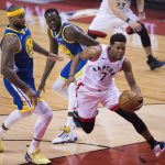 Toronto Raptors guard Kyle Lowry (7) drives to the net against Golden State Warriors center DeMarcus Cousins (0) and forward Draymond Green (23) during second-half basketball action in Game 5 of the NBA Finals in Toronto, Monday, June 10, 2019. (Chris Young/The Canadian Press via AP)