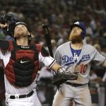 Arizona Diamondbacks catcher Carson Kelly, left, and Los Angeles Dodgers' Justin Turner (10) look up on a wild pitch by Diamondbacks relief pitcher Yoshihisa Hirano as the ball gets past everyone during the seventh inning of a baseball game, Monday, June 24, 2019, in Phoenix. (AP Photo/Ross D. Franklin)