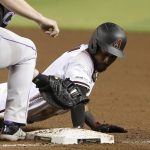 Arizona Diamondbacks' Jarrod Dyson, right, dives safely back to first base as Colorado Rockies first baseman Daniel Murphy, left, applies a late tag on a pickoff throw during the fifth inning of a baseball game Wednesday, June 19, 2019, in Phoenix. (AP Photo/Ross D. Franklin)