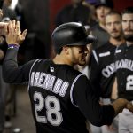 Colorado Rockies' Nolan Arenado (28) celebrates in the dugout after scoring on a double hit by teammate Ryan McMahon during the fourth inning of a baseball game against the Arizona Diamondbacks, Thursday, June 20, 2019, in Phoenix. (AP Photo/Matt York)