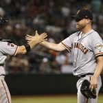 San Francisco Giants relief pitcher Will Smith, right, slaps hands with catcher Stephen Vogt after the team's baseball game against the Arizona Diamondbacks on Friday, June 21, 2019, in Phoenix. The Giants won 11-5. (AP Photo/Ross D. Franklin)