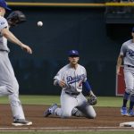 Los Angeles Dodgers first baseman Matt Beaty, middle, tosses the ball to Dodgers starting pitcher Ross Stripling (68) to get Arizona Diamondbacks' Eduardo Escobar out at first base as Dodgers' Austin Barnes (15) looks on during the third inning of a baseball game, Tuesday, June 25, 2019, in Phoenix. (AP Photo/Ross D. Franklin)