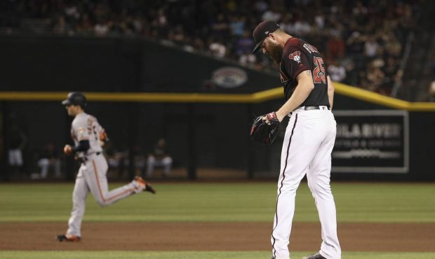 Arizona Diamondbacks relief pitcher Archie Bradley, right, pauses on the mound after giving up a tw...