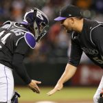 Colorado Rockies relief pitcher Carlos Estevez and catcher Tony Wolters (14) celebrate after the Rockies defeated the Arizona Diamondbacks 8-1 during a baseball game Tuesday, June 18, 2019, in Phoenix. (AP Photo/Rick Scuteri)
