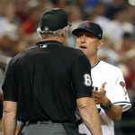 Arizona Diamondbacks manager Torey Lovullo, right, talks to MLB umpire Ted Barrett (65) after a run scored on a past ball in the sixth inning during a baseball game against the Colorado Rockies, Tuesday, June 18, 2019, in Phoenix. (AP Photo/Rick Scuteri)