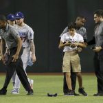 Members of Chase Field security detain a spectator who ran on the field as Los Angeles Dodgers' Kyle Garlick, left, Enrique Hernandez, third from left, and Alex Verdugo, fourth from left, stand nearby after the final out of the team's baseball game against the Arizona Diamondbacks on Tuesday, June 25, 2019, in Phoenix. The Dodgers won 3-2. (AP Photo/Ross D. Franklin)