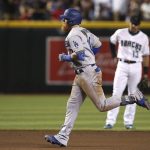 Los Angeles Dodgers' Justin Turner, left, rounds the bases after hitting a home run as Arizona Diamondbacks shortstop Nick Ahmed (13) looks on during the sixth inning of a baseball game, Tuesday, June 25, 2019, in Phoenix. (AP Photo/Ross D. Franklin)