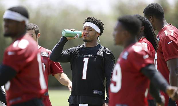 Arizona Cardinals rookie quarterback Kyler Murray takes a drink after stretching out prior to runni...