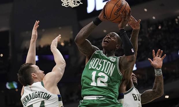 Boston Celtics' Terry Rozier shoots past Milwaukee Bucks' Eric Bledsoe and Pat Connaughton during t...