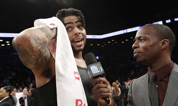 Brooklyn Nets guard D'Angelo Russell, left, is interviewed following the Nets' NBA basketball game ...
