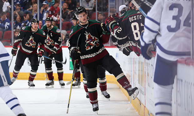 Josh Archibald #45 of the Arizona Coyotes is congratulated by teammates on the bench after scoring ...