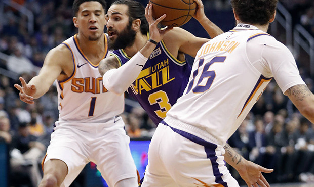 Utah Jazz guard Ricky Rubio (3) drives as Phoenix Suns guard Devin Booker (1) and guard Tyler Johns...