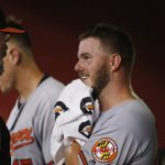 Baltimore Orioles starting pitcher Dylan Bundy, right, smiles as he talks with Orioles pitching coach Doug Brocail, left, in the dugout prior to the seventh inning of a baseball game against the Arizona Diamondbacks, Tuesday, July 23, 2019, in Phoenix. (AP Photo/Ross D. Franklin)