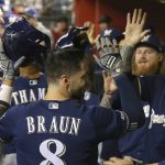 Milwaukee Brewers' Ryan Braun (8) celebrates with teammates, including Yasmani Grandal, right, after scoring against the Arizona Diamondbacks during the second inning of a baseball game Friday, July 19, 2019, in Phoenix. (AP Photo/Ross D. Franklin)