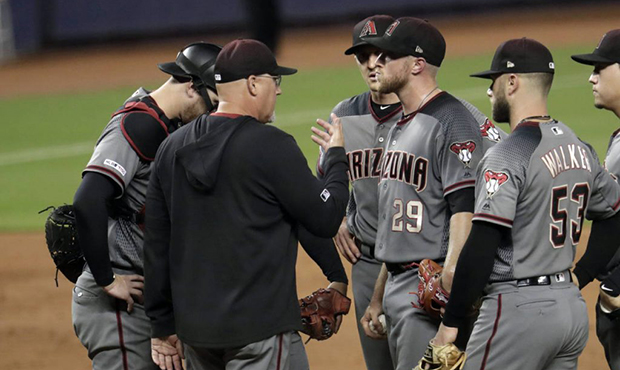 Arizona Diamondbacks pitching coach Mike Butcher, second from left, talks with starting pitcher Mer...