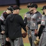 Arizona Diamondbacks pitching coach Mike Butcher, second from left, talks with starting pitcher Merrill Kelly (29) during the second inning of a baseball game against the Miami Marlins, Monday, July 29, 2019, in Miami. The Marlins scored six runs in the second inning. (AP Photo/Lynne Sladky)