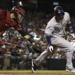 Arizona Diamondbacks catcher Alex Avila, left, tags out Milwaukee Brewers' Keston Hiura, right, after a dropped third strike during the fifth inning of a baseball game Sunday, July 21, 2019, in Phoenix. (AP Photo/Ross D. Franklin)