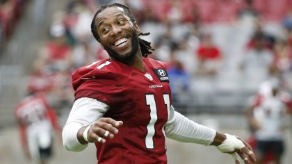 Arizona Cardinals wide receiver Larry Fitzgerald smiles as he talks with teammates as they stretch ...