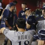 Milwaukee Brewers' Keston Hiura, center, celebrates his run scored against the Arizona Diamondbacks with teammates Christian Yelich, right, and Brent Suter, left, during the eighth inning of a baseball game Sunday, July 21, 2019, in Phoenix. (AP Photo/Ross D. Franklin)