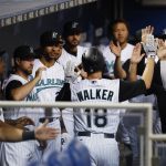 Miami Marlins' Neil Walker (18) is congratulated by teammates after he hit a sacrifice fly scoring Miguel Rojas during the first inning of a baseball game against the Arizona Diamondbacks, Friday, July 26, 2019, in Miami. (AP Photo/Wilfredo Lee)