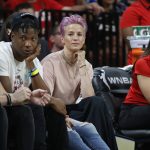 Soccer player Megan Rapinoe, center, watches during the first half of a WNBA All-Star game Saturday, July 27, 2019, in Las Vegas. (AP Photo/John Locher)