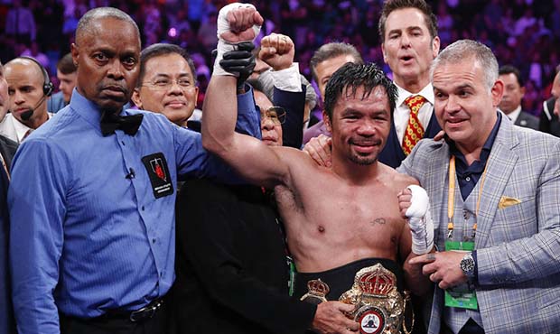 Manny Pacquiao, center, reacts as referee Kenny Bayless holds up his hand signaling his victory ove...