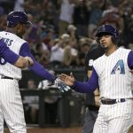 Arizona Diamondbacks' Eduardo Escobar, right, celebrates after scoring against the Los Angeles Dodgers, with Tim Locastro (16) and Adam Jones, second from left, during the fourth inning of a baseball game Thursday, Aug. 29, 2019, in Phoenix. (AP Photo/Ross D. Franklin)