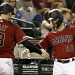 Arizona Diamondbacks' Carson Kelly (18) is greeted by Christian Walker (53) after scoring against the Philadelphia Phillies during the third inning of a baseball game Wednesday, Aug. 7, 2019, in Phoenix. (AP Photo/Ross D. Franklin)