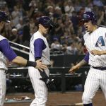 Arizona Diamondbacks' Wilmer Flores, right, and Christian Walker (53) celebrate after scoring against the Los Angeles Dodgers, as Diamondbacks' Nick Ahmed, middle, watches during the fifth inning of a baseball game Thursday, Aug. 29, 2019, in Phoenix. (AP Photo/Ross D. Franklin)