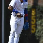 Chicago Cubs shortstop Javier Baez removes grass from his pants after diving to stop a ball hit by Washington Nationals' Brian Dozier during the fourth inning of a baseball game Friday, Aug. 23, 2019, in Chicago. (AP Photo/Matt Marton)