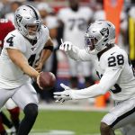 Oakland Raiders quarterback Derek Carr (4) hands off to running back Josh Jacobs (28) during the first half of an an NFL football game against the Arizona Cardinals, Thursday, Aug. 15, 2019, in Glendale, Ariz. (AP Photo/Ralph Freso)