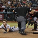 Washington Nationals' Trea Turner, left, scores a run on a ball hit by Anthony Rendon in the seventh inning during a baseball game against the Arizona Diamondbacks, Sunday, Aug. 4, 2019, in Phoenix. (AP Photo/Rick Scuteri)