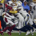 Arizona Cardinals wide receiver Larry Fitzgerald, left is tackled by Los Angeles Chargers defensive back Desmond King (20), Los Angeles Chargers defensive back Desmond King, rear, and Los Angeles Chargers outside linebacker Kyzir White, right, during the first half of an NFL preseason football game, Thursday, Aug. 8, 2019, in Glendale, Ariz. (AP Photo/Ross D. Franklin)