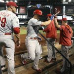 Philadelphia Phillies' Scott Kingery, second from left, celebrates his home run against the Arizona Diamondbacks with manager Gabe Kapler (19), bench coach Rob Thomson, second from right, and hitting coach John Mallee, right, during the second inning of a baseball game Monday, Aug. 5, 2019, in Phoenix. (AP Photo/Ross D. Franklin)