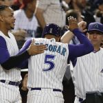 Arizona Diamondbacks' Eduardo Escobar (5) is congratulated by Ketel Marte, left, and manager Torey Lovullo, right, after scoring against the Los Angeles Dodgers during the fourth inning of a baseball game Thursday, Aug. 29, 2019, in Phoenix. (AP Photo/Ross D. Franklin)
