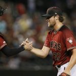 Arizona Diamondbacks relief pitcher Kevin Ginkel (37) slaps hands with Diamondbacks catcher Carson Kelly, left, after the final out of the team's baseball game against the Philadelphia Phillies on Wednesday, Aug. 7, 2019, in Phoenix. The Diamondbacks defeated the Phillies 6-1. (AP Photo/Ross D. Franklin)
