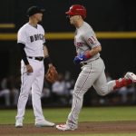 Philadelphia Phillies' Corey Dickerson, right, rounds the bases after hitting a solo home run as Arizona Diamondbacks Jake Lamb looks away during the first inning of a baseball game Tuesday, Aug. 6, 2019, in Phoenix. (AP Photo/Matt York)