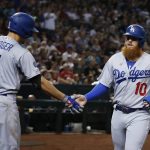Los Angeles Dodgers' Justin Turner (10) is congratulated by Corey Seager after scoring against the Arizona Diamondbacks during the third inning of a baseball game Friday, Aug. 30, 2019, in Phoenix. (AP Photo/Ross D. Franklin)