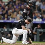 Colorado Rockies' Daniel Murphy, front, reacts after hitting a line-drive foul ball into the right field stands as Arizona Diamondbacks catcher Carson Kelly looks on in the fourth inning of a baseball game Monday, Aug. 12, 2019, in Denver. (AP Photo/David Zalubowski)
