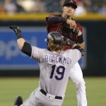 Arizona Diamondbacks shortstop Nick Ahmed turns the double play while avoiding Colorado Rockies' Charlie Blackmon (19) on a ball hit by Ryan McMahon in the seventh inning during a baseball game, Wednesday, Aug. 21, 2019, in Phoenix. (AP Photo/Rick Scuteri)